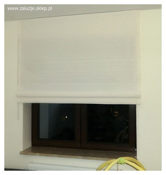Elegancja i komfort - rzymska roleta materiałowa. Harmonijnie dopasowuje się do stylu wnętrza, tworząc przyjemną atmosferę.