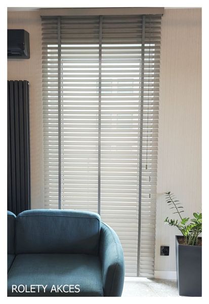 Szare żaluzje drewniane - elegancja i nowoczesność w Twoim salonie.