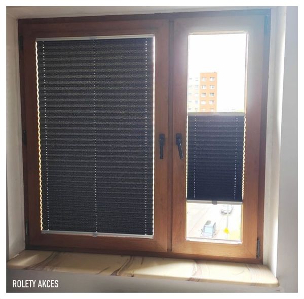 Czarne plisy zamontowane na drewnianym oknie