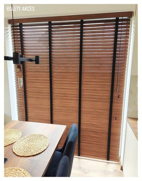 Szerokie żaluzje drewnopodobne w kolorze naturalnego drewna zamontowane w jadalni.