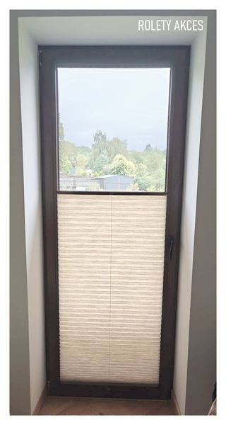 Beżowa plisa Akces na drzwiach balkonowych w ramie orzech – ciepło i elegancja w jednym.